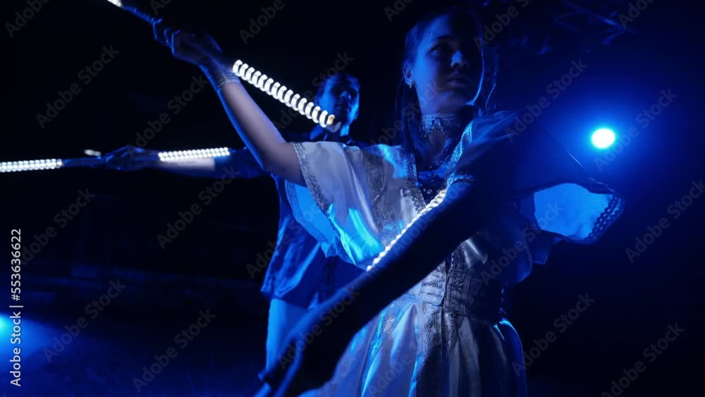 Light LED dance show. Beautiful young girl in a dress and a guy twist