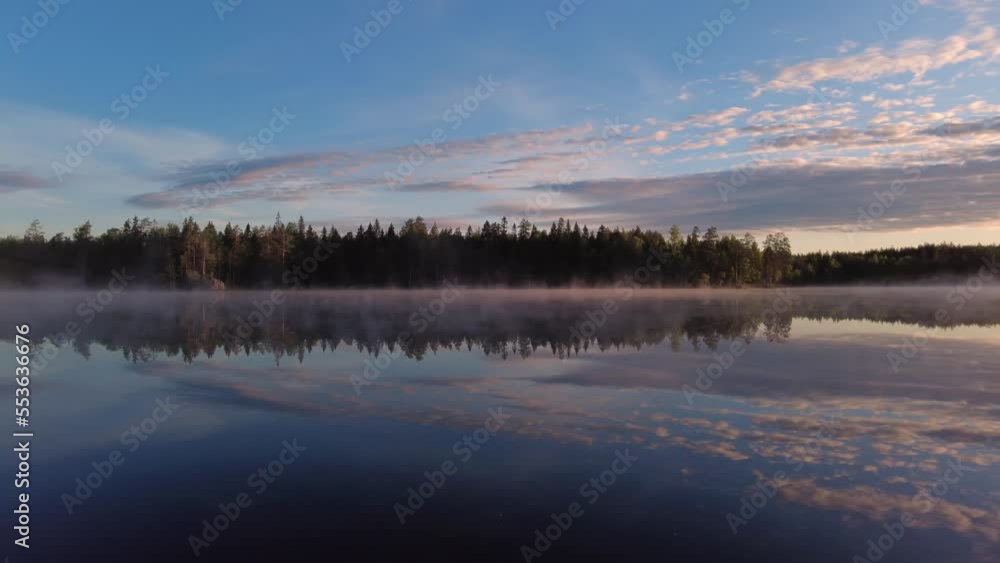 Summer sunrise by beautiful calm misty lake scenery in the wilderness. Beautiful reflection from the lake. Pan from left to right. Summer sunrise by beautiful calm misty lake scenery in the wilderness. Beautiful reflection from the lake. Pan from left to right.