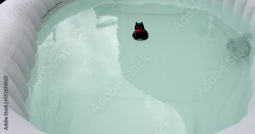 Mid shot of an inflatable hot tub starting  it air jets, bubbles with batman rubber duck! photo