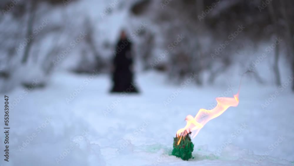 black witch on the background of fire. witch rite. mysticism and black magic. the witch walks in the snow black witch on the background of fire. witch rite. mysticism and black magic. the witch walks in the snow
