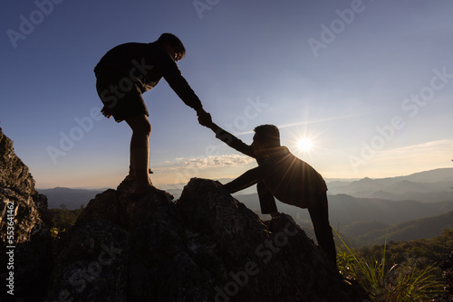 Foto Silhouette of helping hand between two climber
