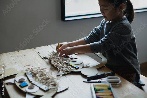 鬼のお面をテーブルの上で工作で作る子供 photo