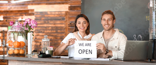 Happy young business owners in their new cafe