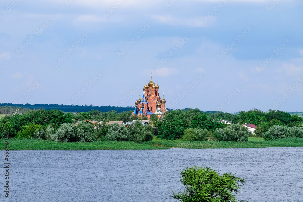 Beautiful view of rural buildings, church and river on sunny day