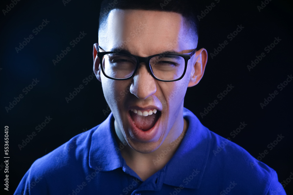Obraz premium Portrait of emotional Asian man on black background