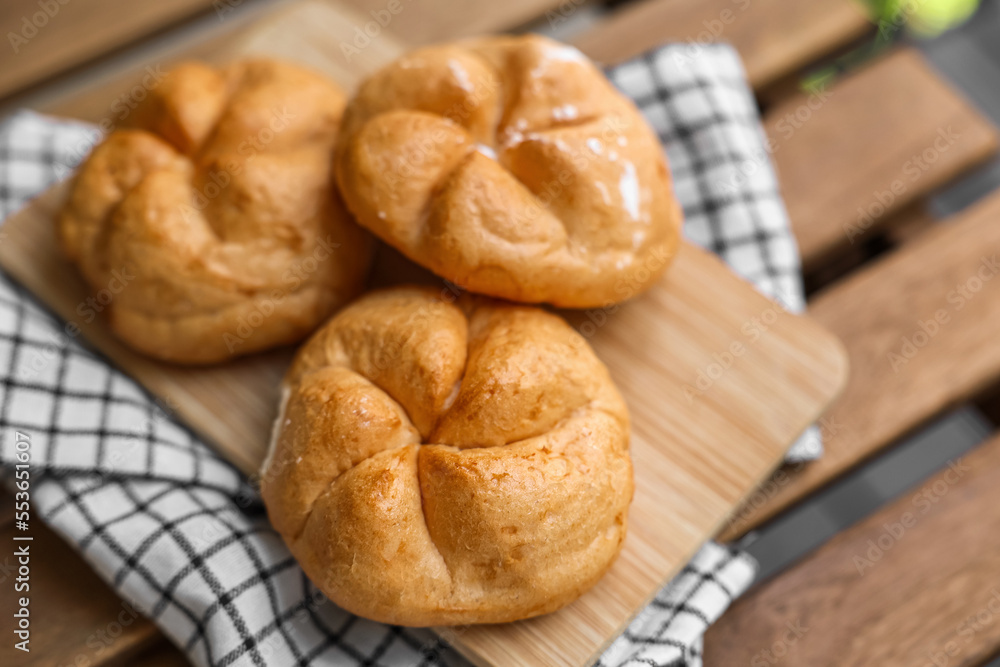 Kaiser rolls on wooden board, closeup Kaiser rolls on wooden board, closeup