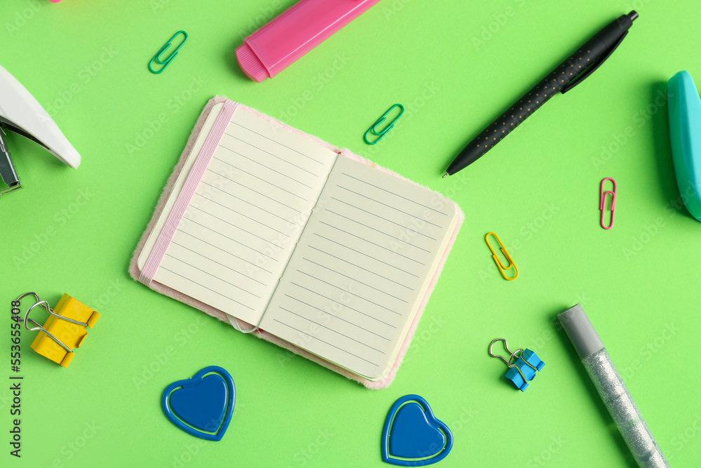Set of different stationery and notebook on green background Set of different stationery and notebook on green background