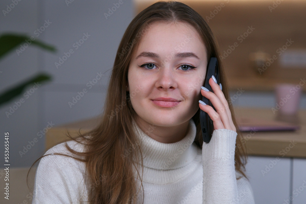 happy beautiful girl, young woman talking on cell mobile phone at home, smile, calling, looking at camera happy beautiful girl, young woman talking on cell mobile phone at home, smile, calling, looking at camera
