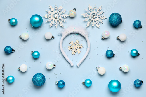 Composition with Christmas headband and beautiful balls on light blue background
