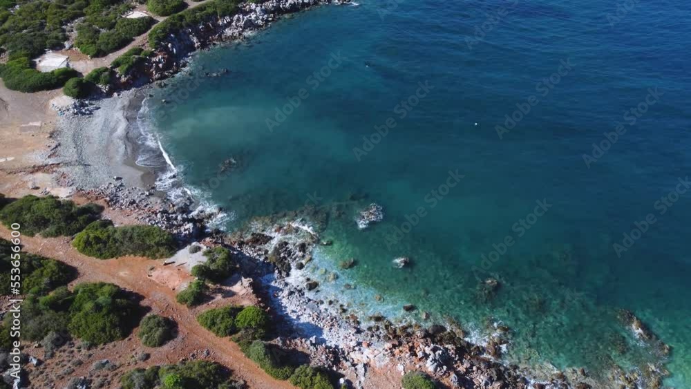 Shore of Crete Island with waves hitting the beach surrounded by forest and trails Shore of Crete Island with waves hitting the beach surrounded by forest and trails