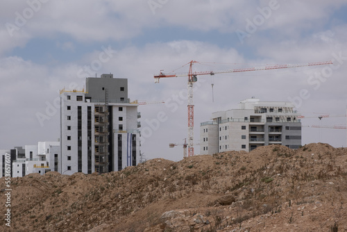 Development, new construction in the south district of Israel, new apartment buildings. Building a new site with heaps of ground in front. © ArieStudio