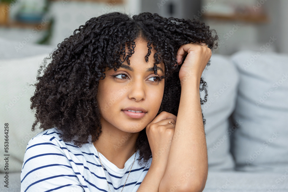 Portrait of a beautiful woman smiling at home. African woman in casual looking at camera with copy space. Cheerful mixed race girl relaxing at home Portrait of a beautiful woman smiling at home. African woman in casual looking at camera with copy space. Cheerful mixed race girl relaxing at home