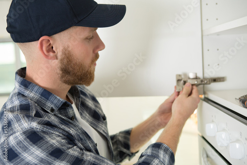 repairman fixing a cabinet door