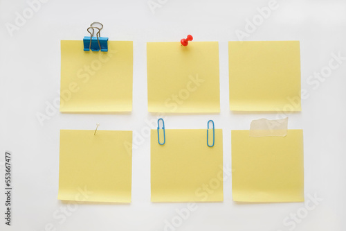 Collection of empty pinned yellow memo papers on a white background