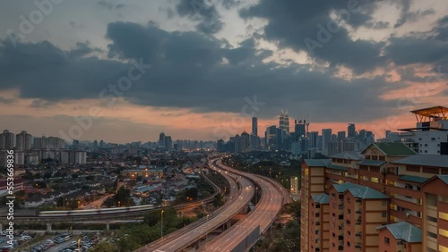 Aerial high angle sunrise view time lapse overlooking busy expressway and streets against a city skyline and an urban village at dawm in Kuala Lumpur, Malaysia. Prores 4KUHD Timelapse. photo