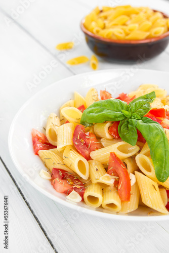 Piatto di pasta condita con pomodoro fresco, olio di oliva, basilico e origano - cibo italiano - dieta mediterranea