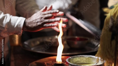 Closeup of hands taking arti and tirtha inside the temple photo