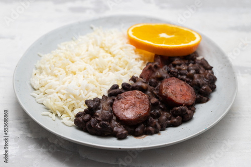 Typical brazilian food beans with sausages and rice Feijoada on white dish