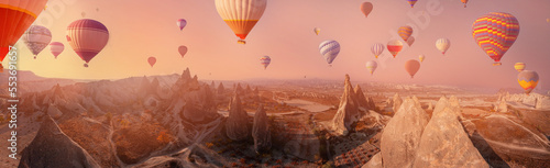 Old cave in big stone, hot air balloons fly over deep canyons, valleys Cappadocia Goreme National Park, Banner Turkey Travel tourist concept photo