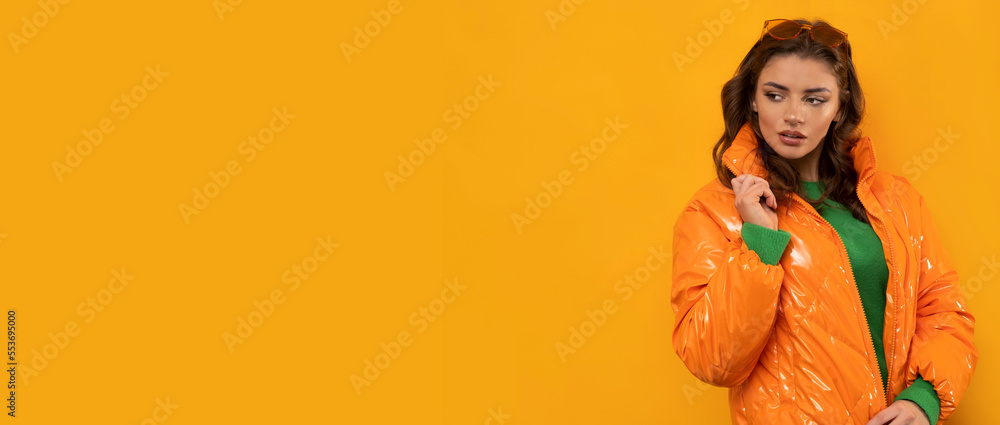 Winter clothes on pretty brunette with long hairs on isolated orange background. Winter clothes on pretty brunette with long hairs on isolated orange background.