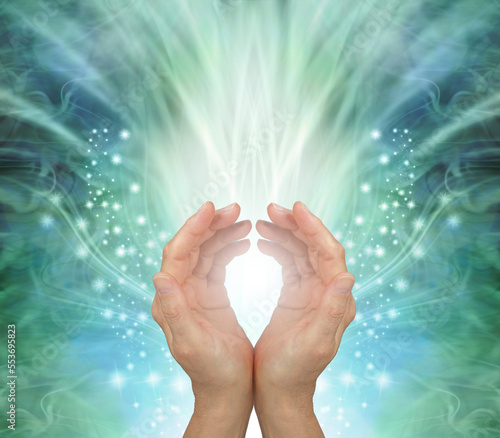 Channeling heart chakra healing energy to you - female cupped hands against a stunning radiating ethereal green energy field background with copy space for messages
 photo