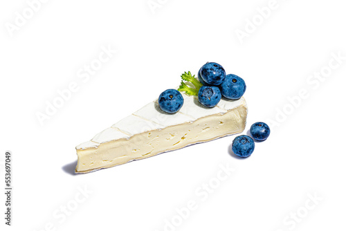 A piece of Camembert with blueberries isolated on white background. Cheese board concept photo
