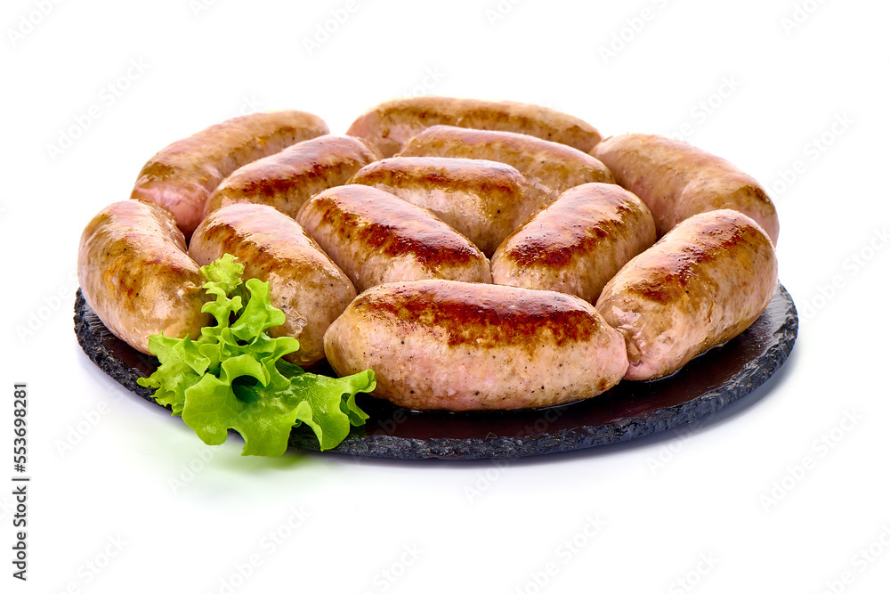 Grilled pork bangers on rustic slate stone plate, isolated on white background.