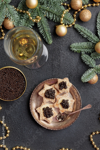 Black caviar appetizers stars on a christmas decorated black table