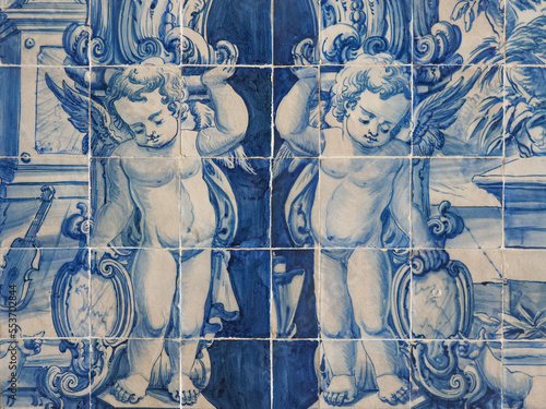 Traditional Portuguese, glazed ceramic tiles on building wall. Azulejos white, blue ornate pattern, for design, backdrop. Decorative painted tiles, religious theme with angels.