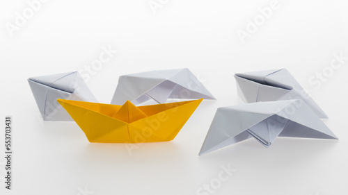 Yellow paper boat and a lot of sinking ships