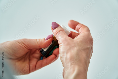Senior woman's hands opening pill bottle