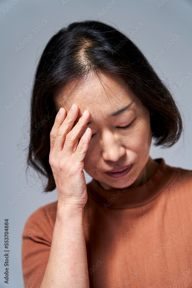 Mature Asian woman having a headache Mature Asian woman having a headache