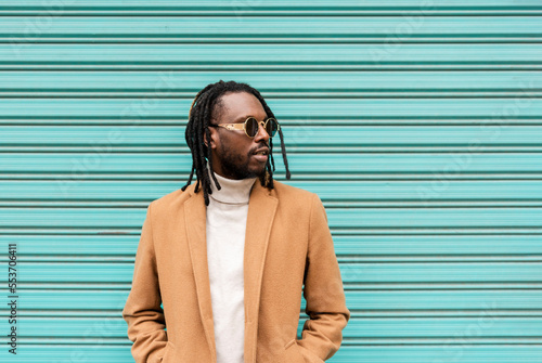 Photo handsome african american man with braids wearing stylish sunglasses looking awa