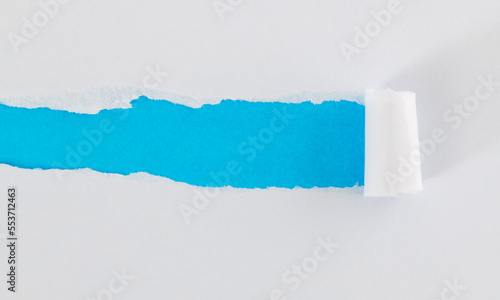 White torn paper on blue background