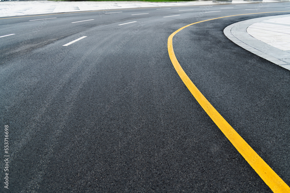 Asphalt road with white stripes and yellow lines