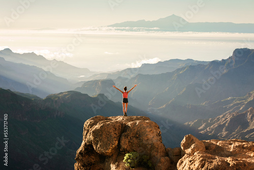 Fotografia Young girl standing on a rock with the amazing view of Roque Nublo natural park