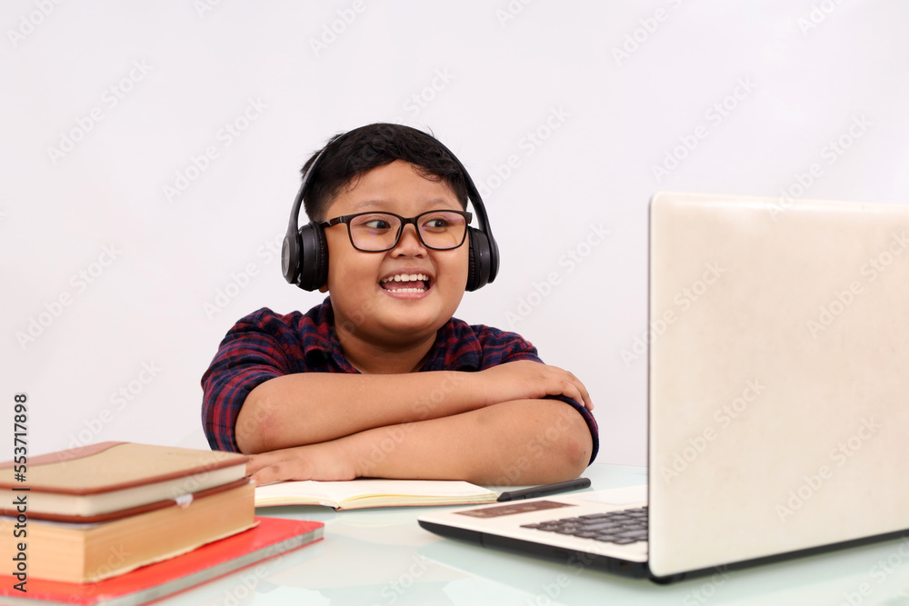 Happy asian school boy studying online using laptop. Isolated on white background with copyspace Happy asian school boy studying online using laptop. Isolated on white background with copyspace