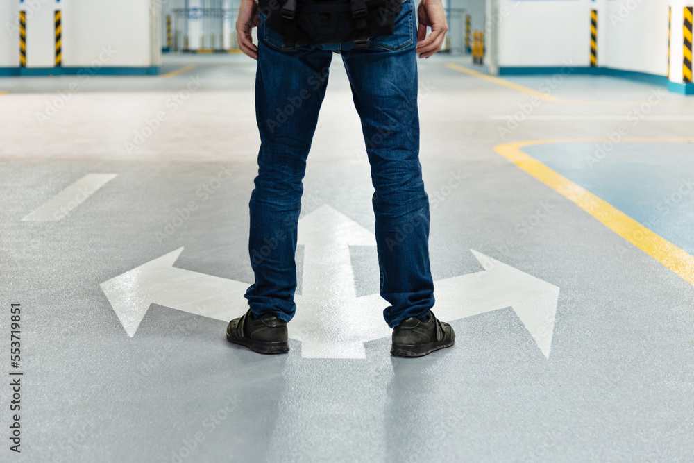 Obraz premium Man legs standing in front of three direction arrows