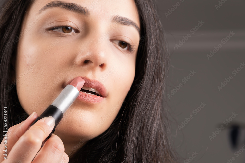 Holding lipstick, close up image of woman holding lipstick. Rouging lip balm. Gently open her mouth. Caucasian girl doing her own make up. Lifestyle of millennial female at home. Attractive brunette. Holding lipstick, close up image of woman holding lipstick. Rouging lip balm. Gently open her mouth. Caucasian girl doing her own make up. Lifestyle of millennial female at home. Attractive brunette.