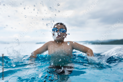 Boy swimming and spitting water from mouth