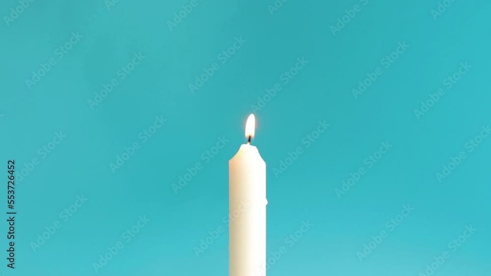 Burning white candle isolated on bright blue background. Copy space. Burning white candle isolated on bright blue background. Copy space.