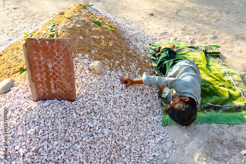 sad orphan children weeping at their mother's grave photo