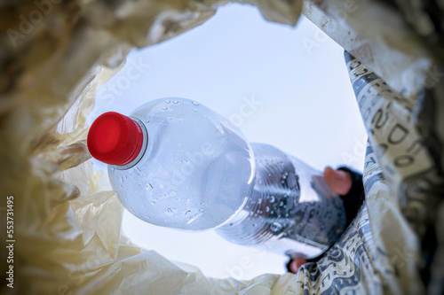 PET-Flasche wird in einem Mülleimer geworfen photo