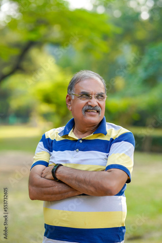 confident Indian old man standing at park