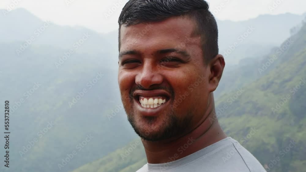 Portrait of asian happy man looking at camera and smiling on mountain background in nature park, face close-up. Sincere human emotions concept. He has dark skin, brown eyes and shirt brunet hair. Portrait of asian happy man looking at camera and smiling on mountain background in nature park, face close-up. Sincere human emotions concept. He has dark skin, brown eyes and shirt brunet hair.