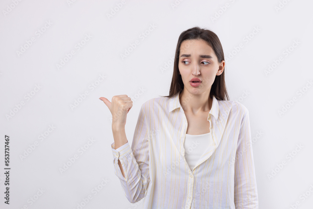 Happy young caucasian female in a shirt pointing fingers away Happy young caucasian female in a shirt pointing fingers away