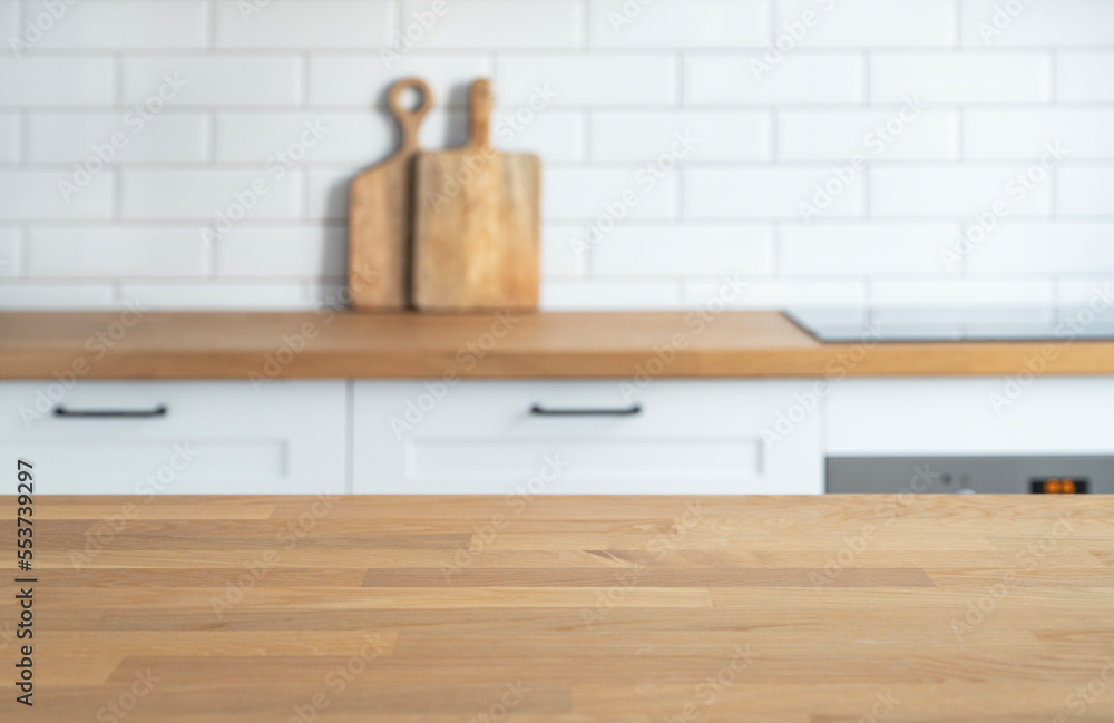 ..Wooden oak countertop with free space for mounting a product or layout against the background of a blurred white kitchen. ..Wooden oak countertop with free space for mounting a product or layout against the background of a blurred white kitchen.