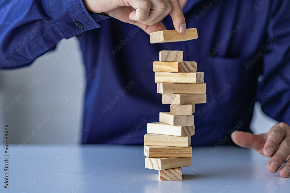 planning, risk and project management strategies in business Businessman and engineer gambling placing wooden blocks on tower Business and construction success concept planning, risk and project management strategies in business Businessman and engineer gambling placing wooden blocks on tower Business and construction success concept