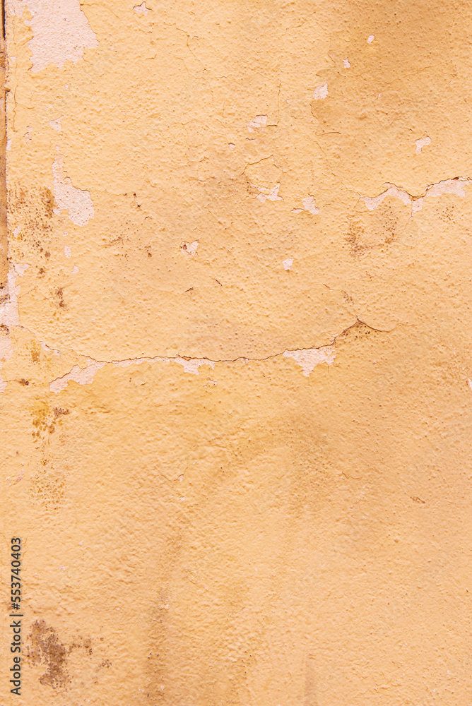 Rough surface of a wall with peeling paint of pale cream yellow color Rough surface of a wall with peeling paint of pale cream yellow color