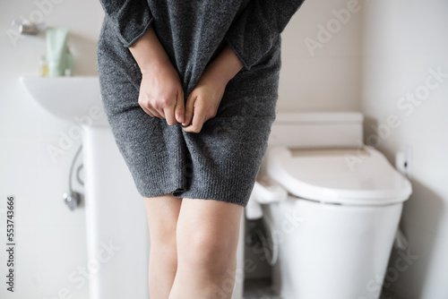 Papier peint A woman wearing knitwear is complaining of pain from urinary incontinence in fro